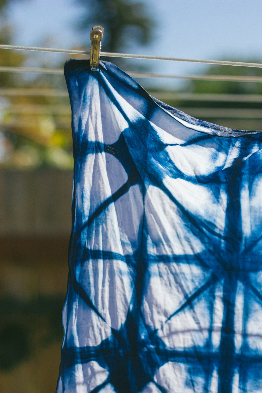 Shibori dyed linen hanging from line by Conscious by Chloé